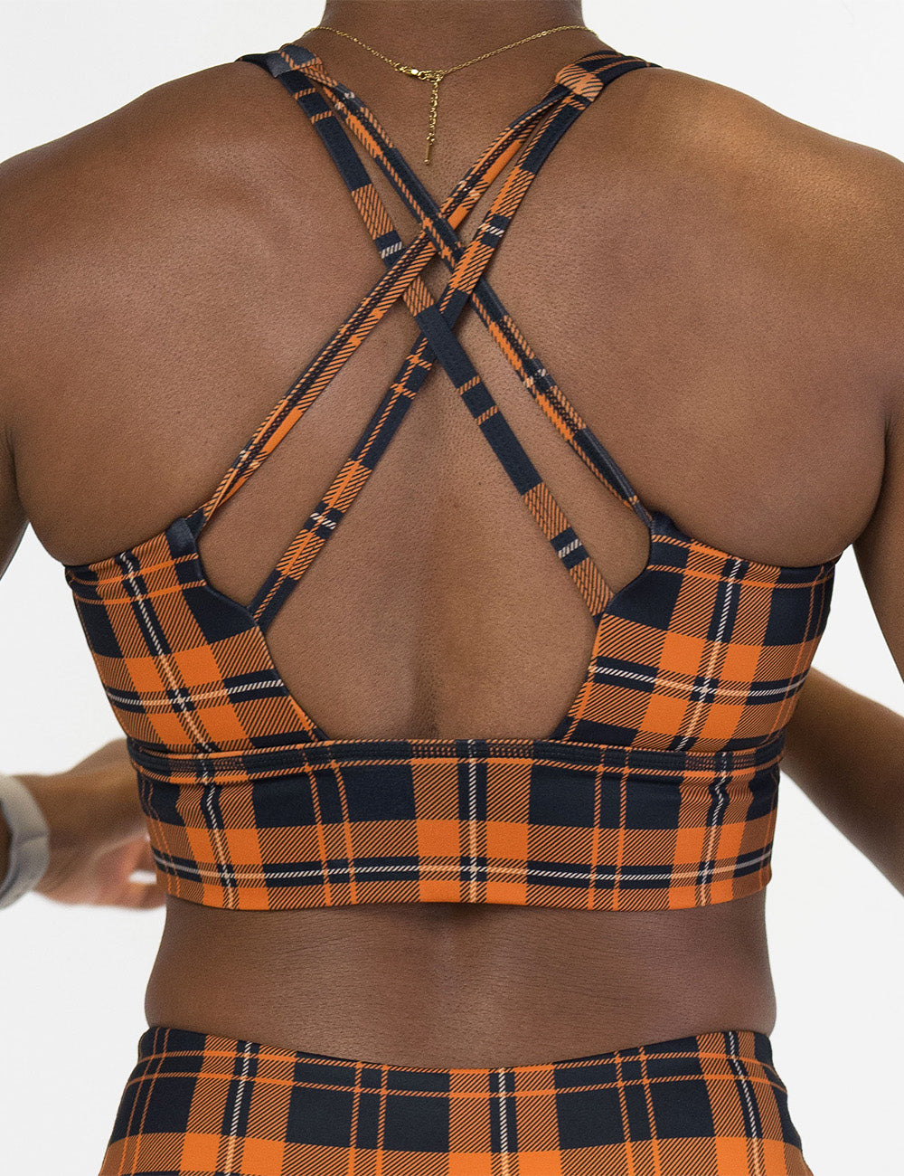 back of the black and orange plaid bra against a white background