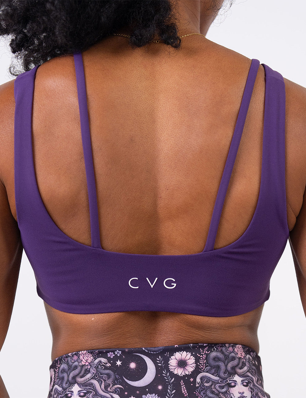 back of the solid purple sports bra against a white background