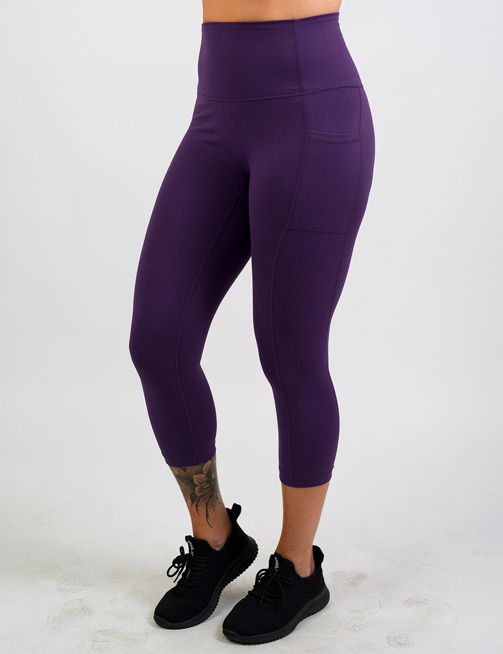 front of the solid purple capri leggings against a white background
