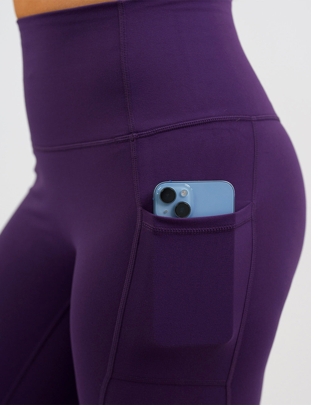 close up of the solid purple leggings with a phone in its pocket