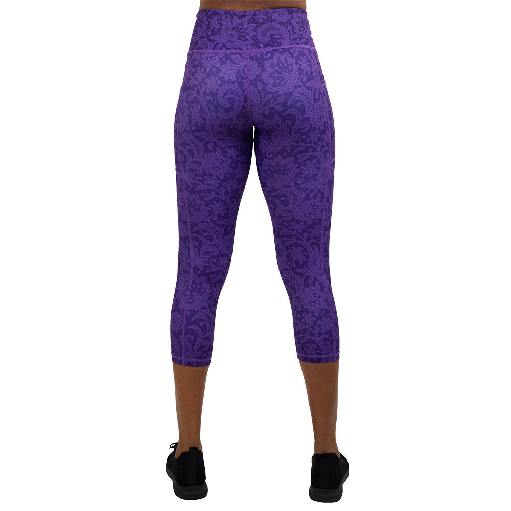 back of the purple flower artwork capri leggings against a white background