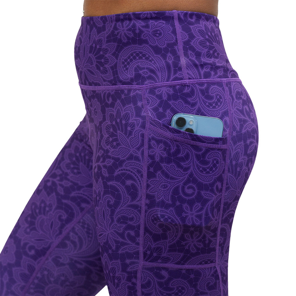 purple flower artwork leggings facing the side with a phone in the pocket against a white background