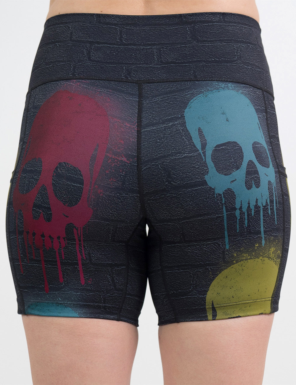 back of the 5 inch black brick pattern with blue, red, and yellow skull spray paint patterns shorts against a white background