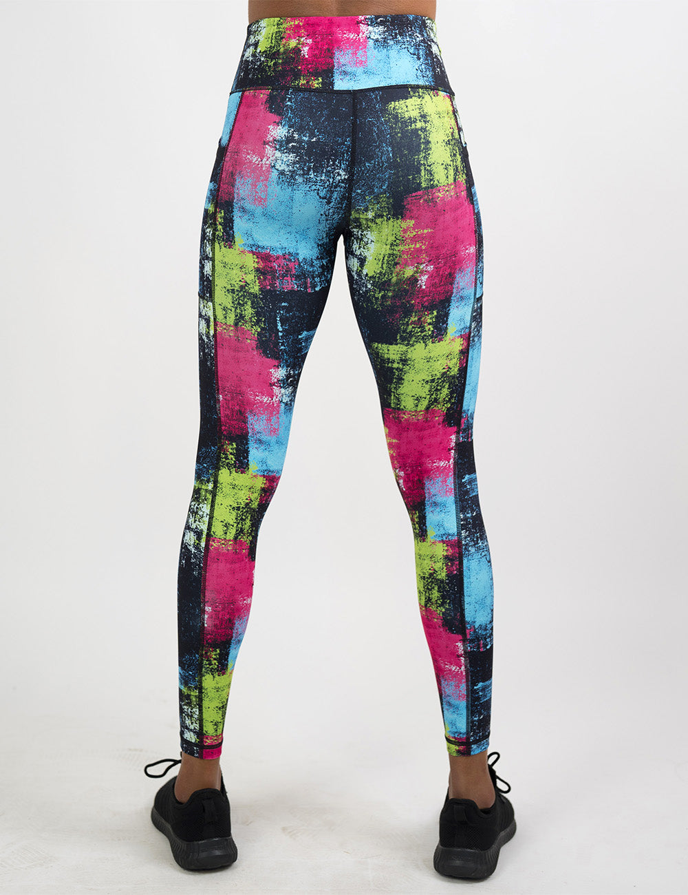 back of the green, pink, and blue grunge pattern full length leggings against a white background
