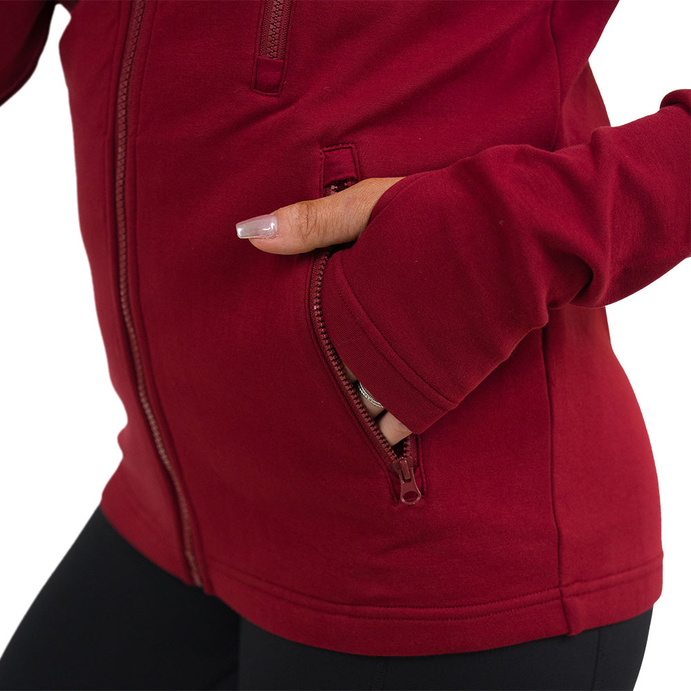 close up of the dark red rest day zip up sweatshirt with a hand in the pocket against a white background
