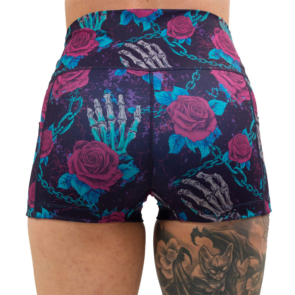back of the roses and skeleton hands connected by chain links pattern 2,5 inch shorts against a white background