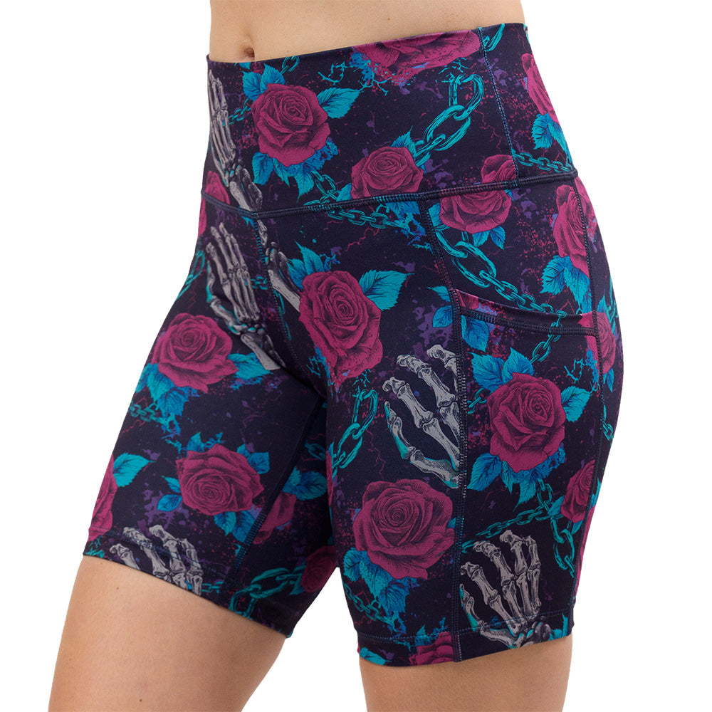 roses and skeleton hands connected by chain links pattern 7 inch shorts facing the front against a white background
