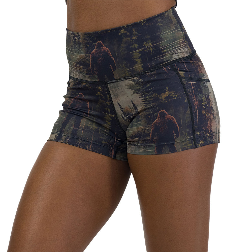 shorts with a forest design and a bigfoot graphic on it