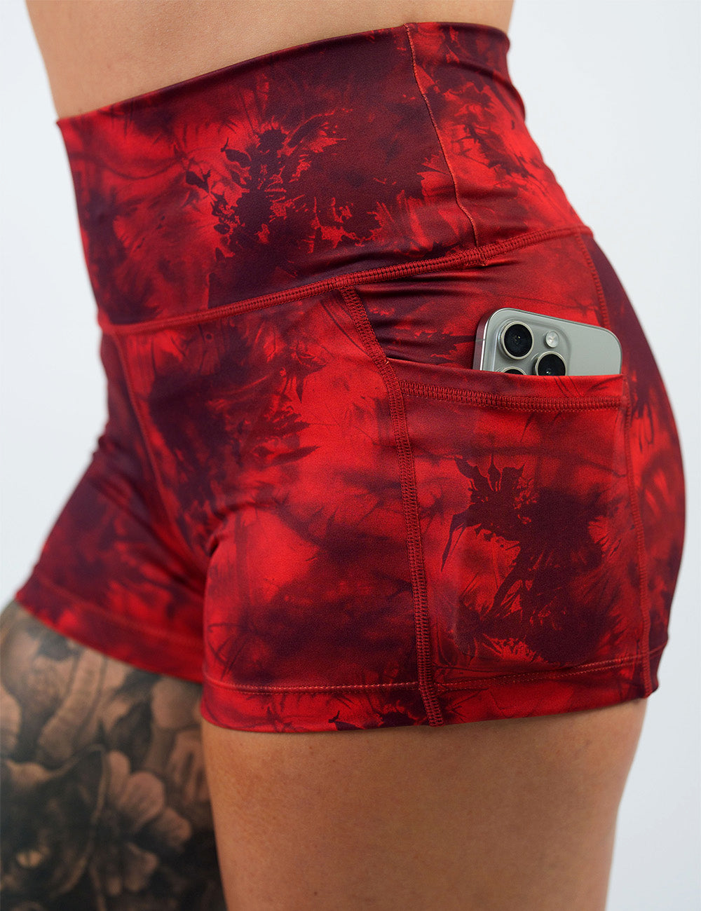 close up of the 2.5 inch red tie dye shorts with a phone in its pocket