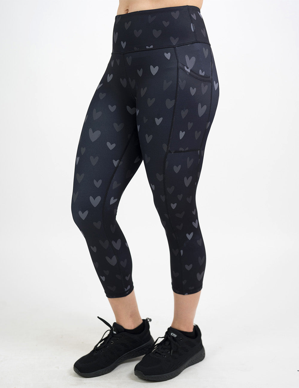 front of the capri black leggings with light and dark grey hearts against a white background