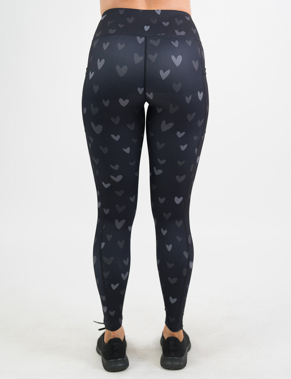 back of the full length black leggings with light and dark grey hearts against a white background