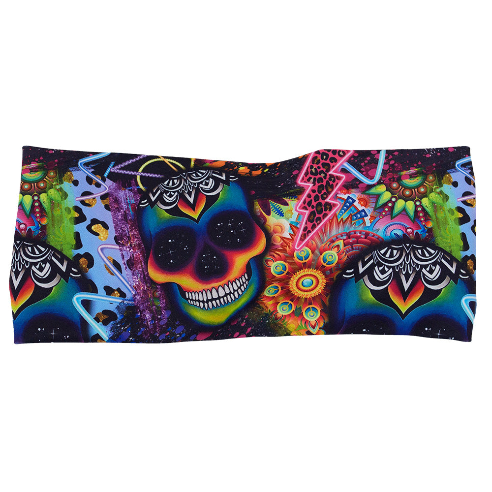 front of the brightly colored psychedelic skulls pattern against a busy background full of designs headband against a white background
