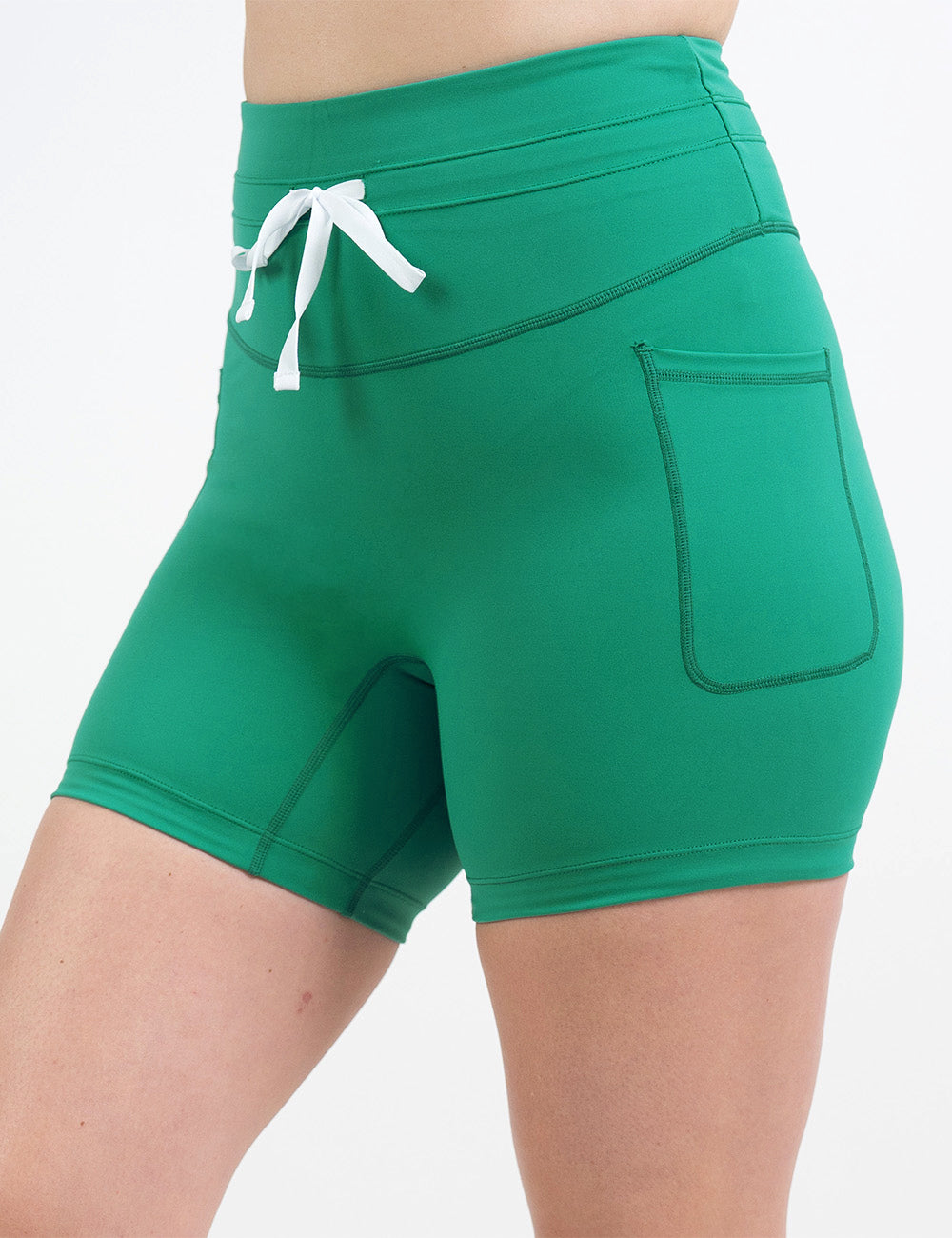 front of the 5 inch omni style green shorts with a white drawstring against a white background