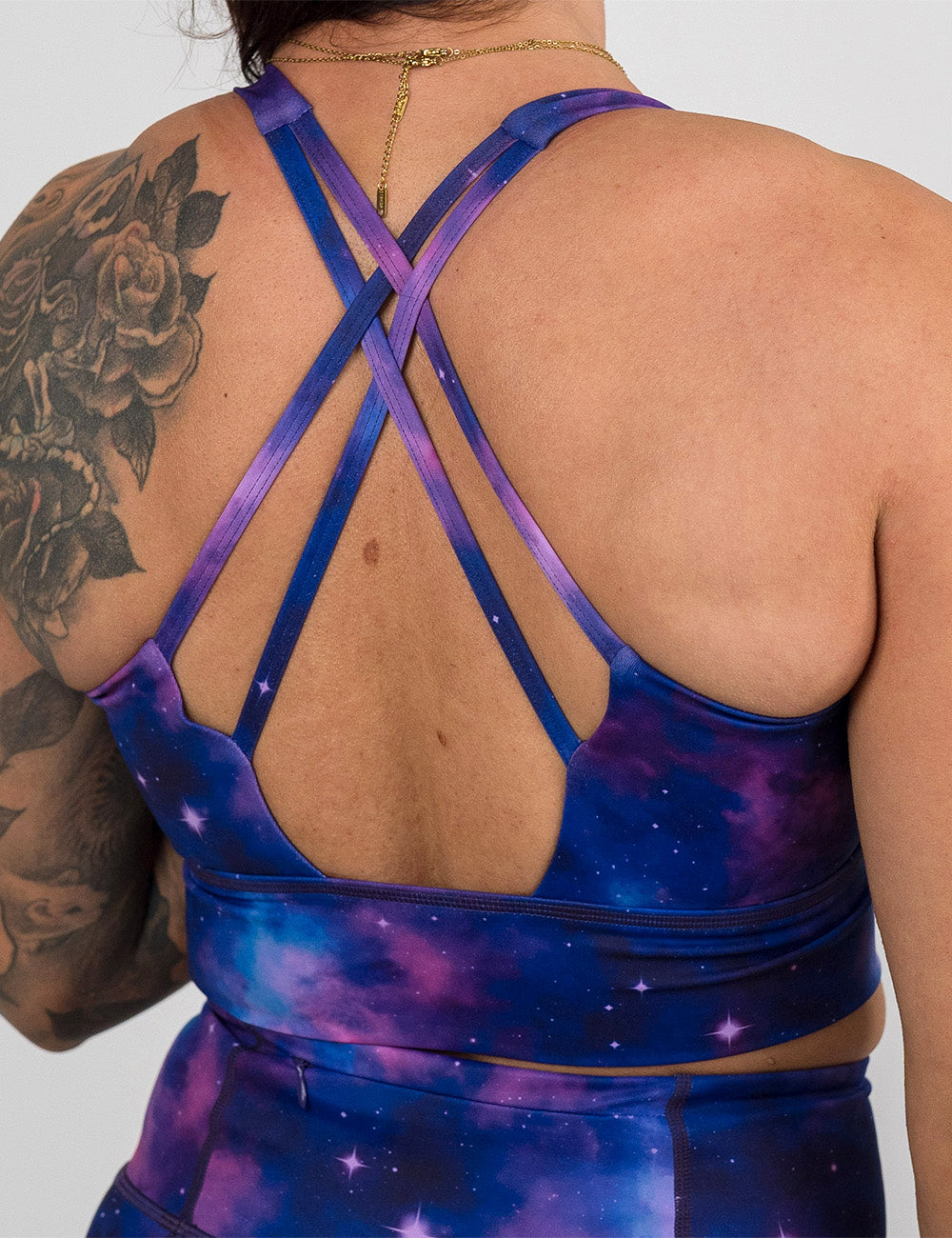 back of the purple and blue space longline bra against a white background