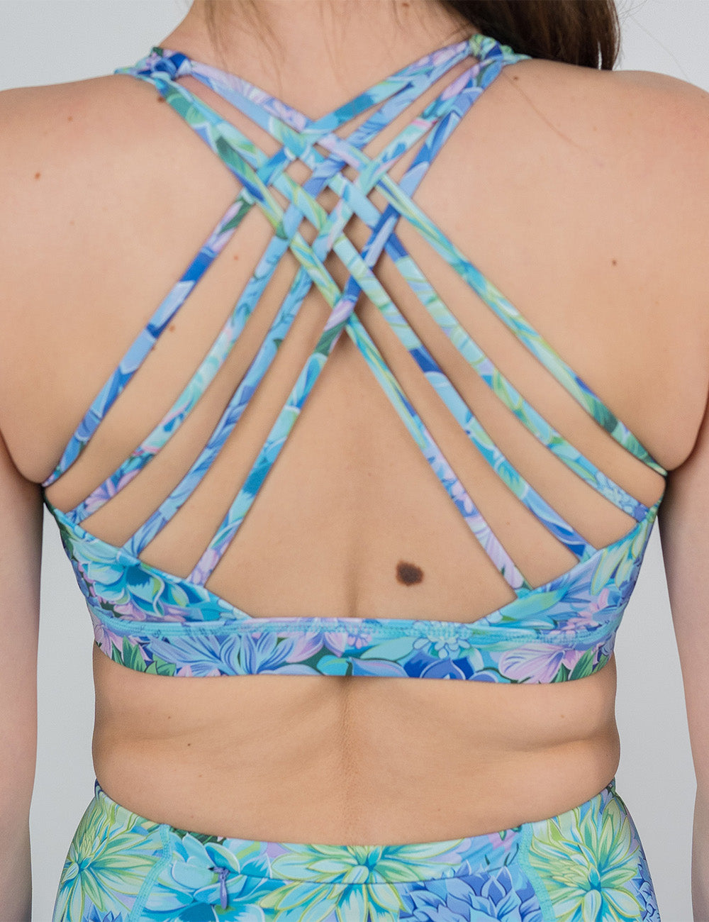 back of the blue flower pattern butterfly back bra against a white background