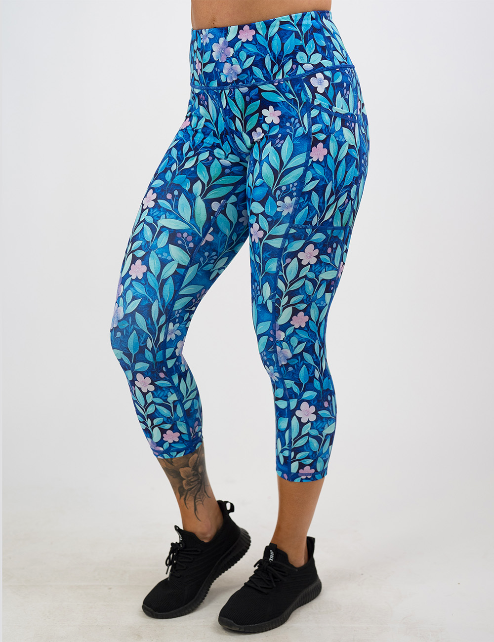 capri blue flowers and vines leggings facing the front against a white background