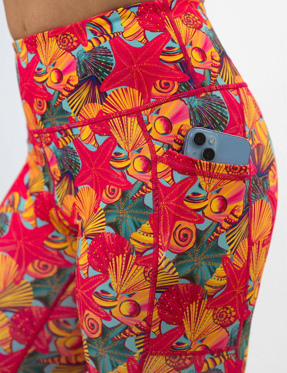 back of the front of the red starfish with a yellow and blue shell background capri leggings against a white background