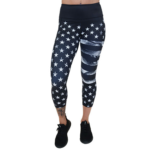 capri length black leggings with white American flag design on it