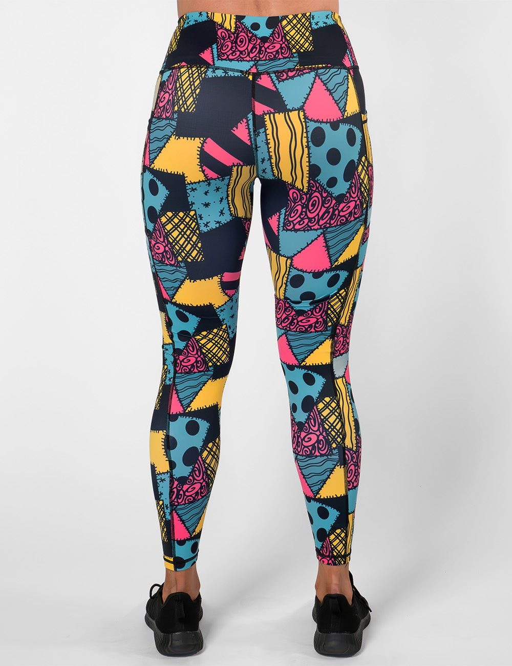 back of the yellow, teal, and pink patchwork design full length leggings against a white background