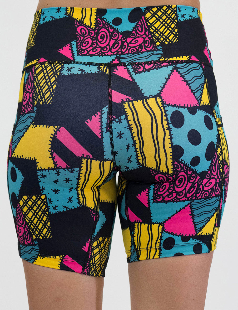 back of the 7 inch yellow, teal, and pink patchwork design shorts against a white background