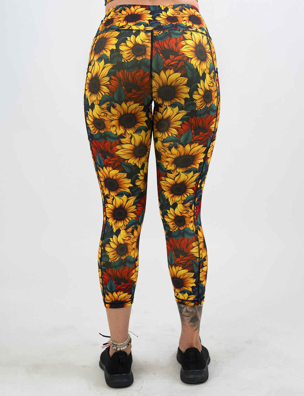 back of the sunflower with red flowers capri leggings against a white background