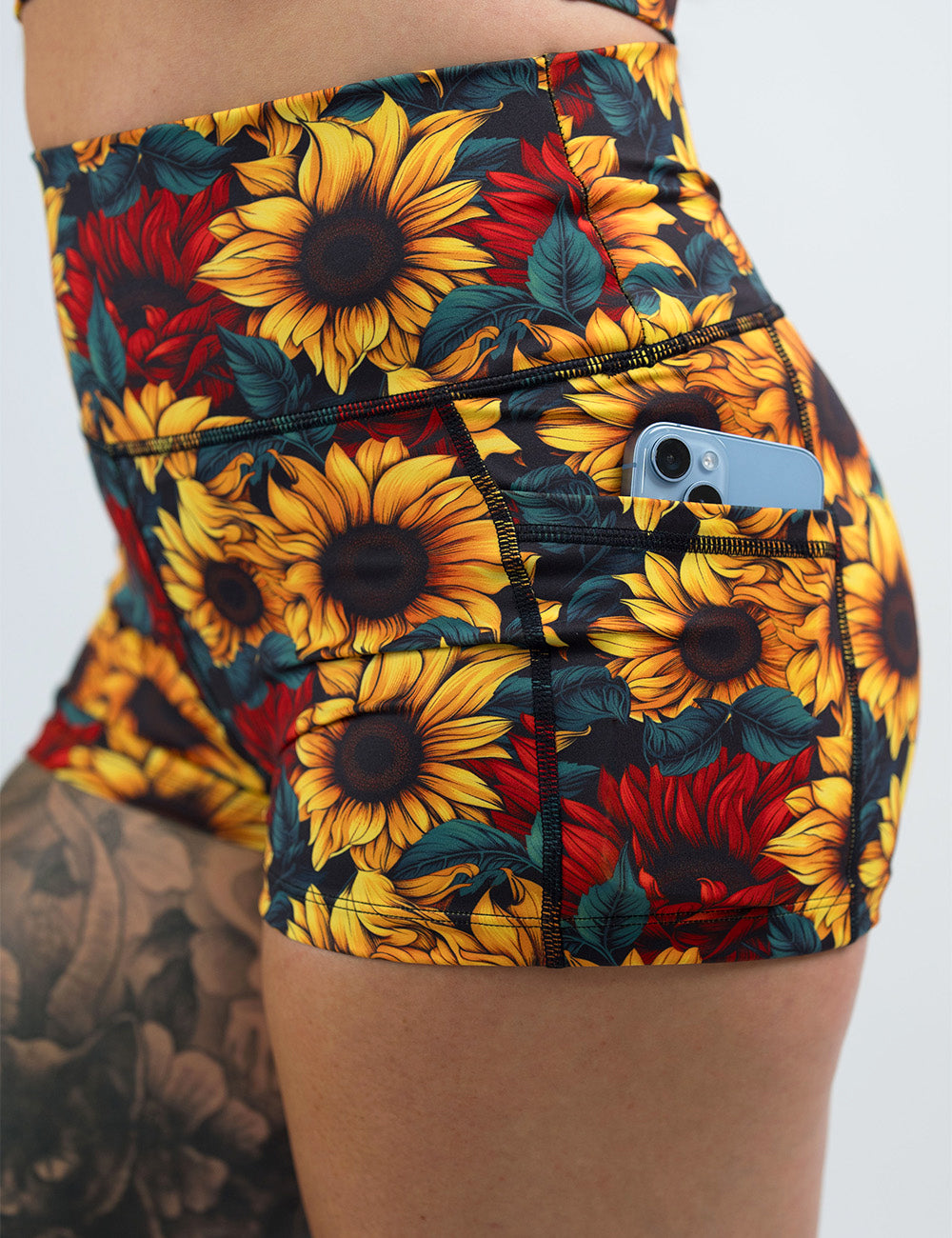 close up of the 2.5 inch sunflower with red flowers shorts with a phone in its pocket