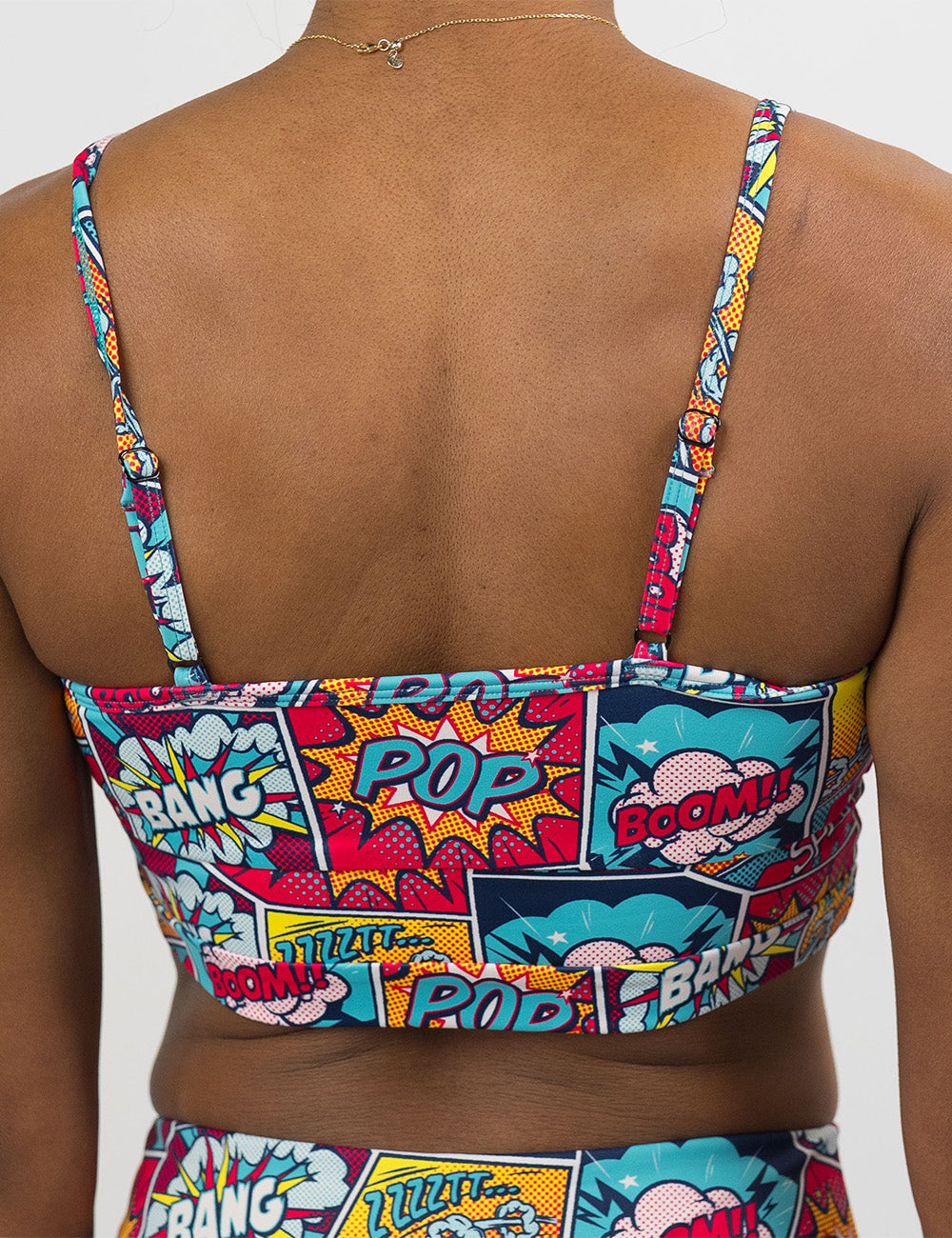 back of the comic book panel inspired patterned swimsuit top against a white backround