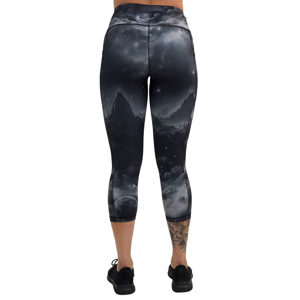 back of black capri leggings with mountain and star pattern against a white background