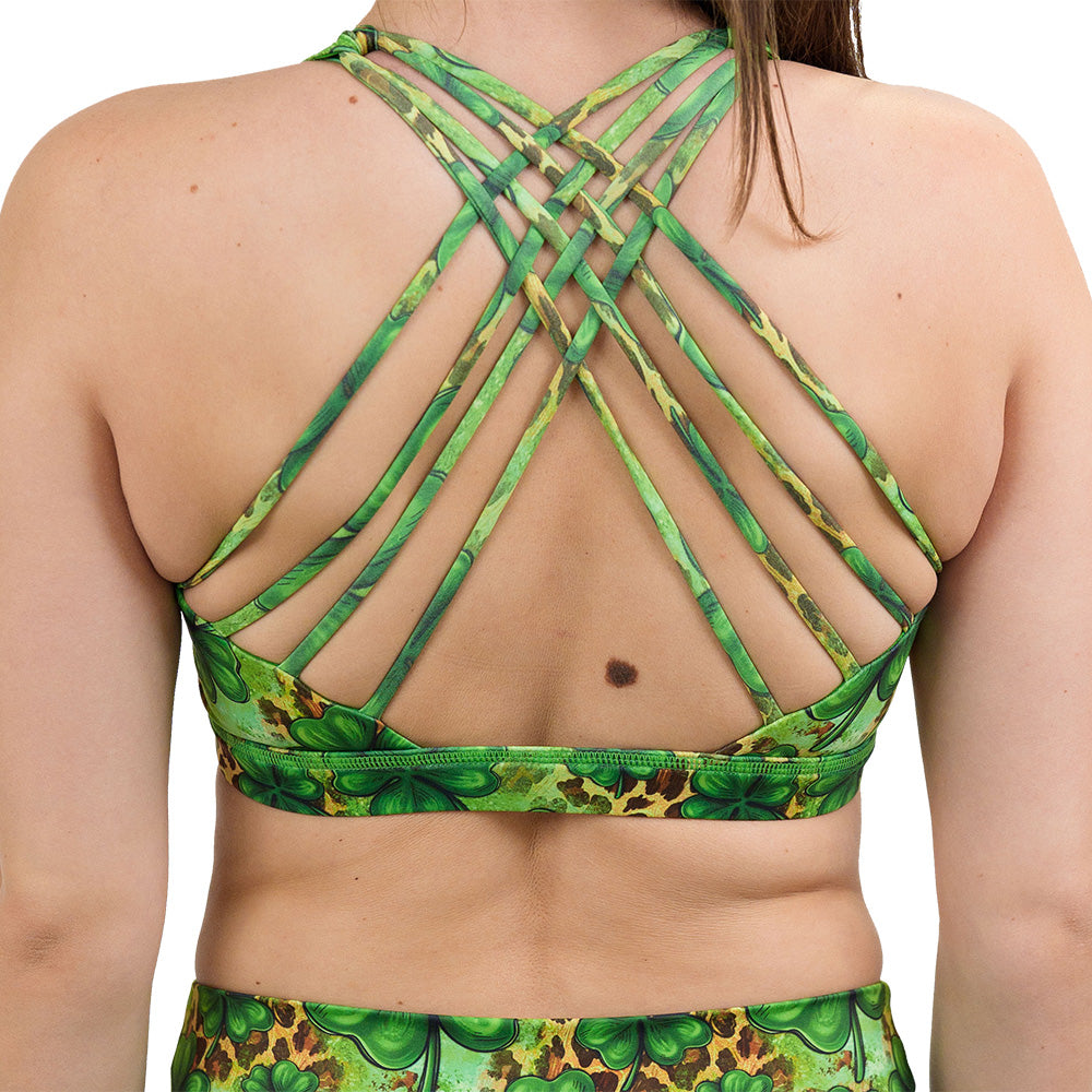 back of the clover pattern against a cheetah print and green background butterfly back bra against a white background