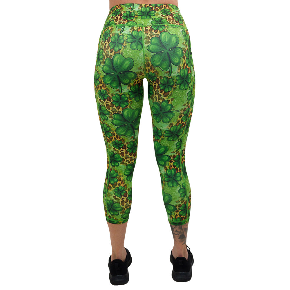 back of the clover pattern against a cheetah print and green background capri leggings against a white background