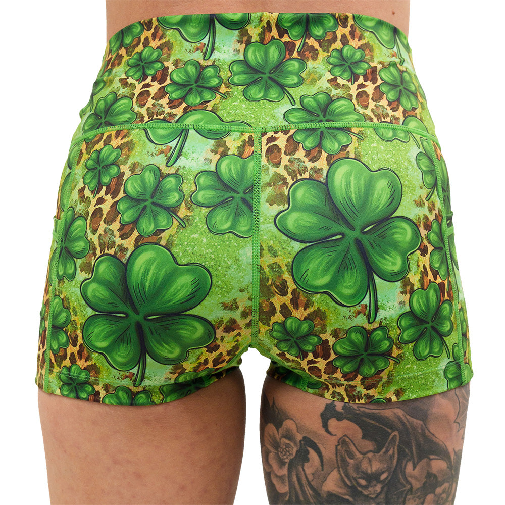 back of the clover pattern against a cheetah print and green background 2.5 inch shorts against a white background