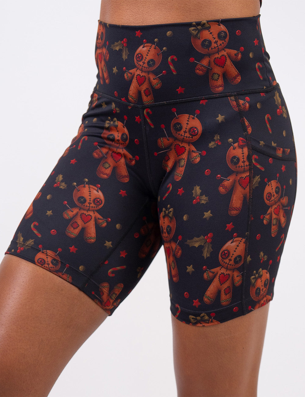 front of the gingerbread voodoo dolls with pins in them surrounded by berries and stars on a black background 7 inch shorts