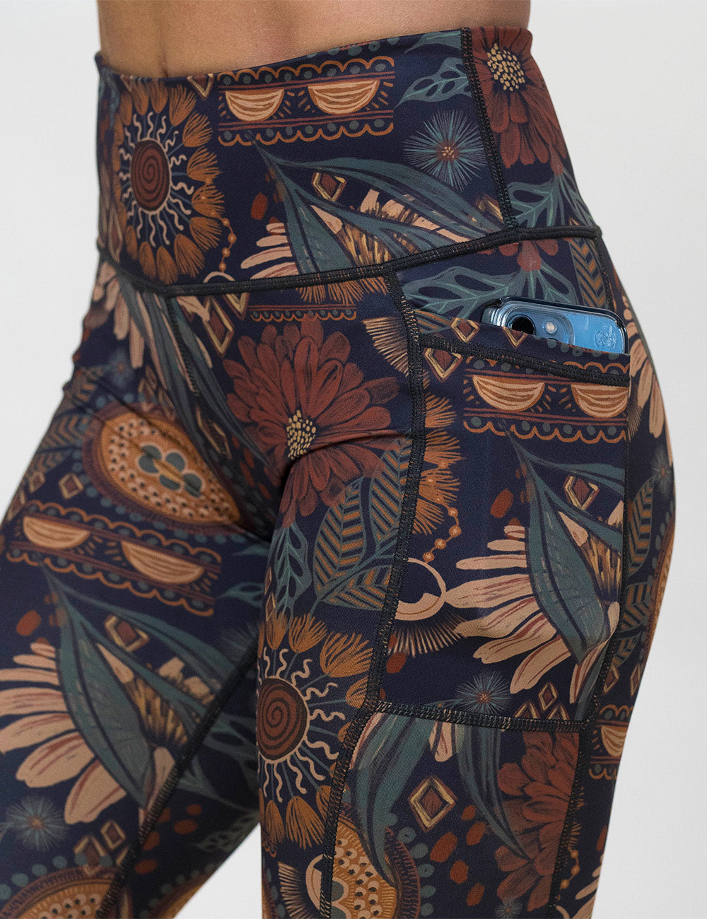 close up of the paisley flowers leggings with a phone in its pocket