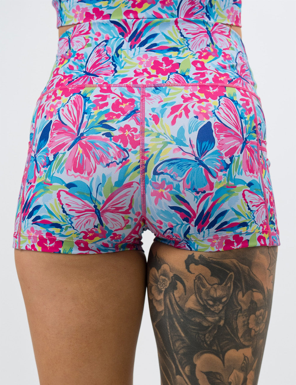 back of the 2.5 inch pink butterflies against a colorful floral background shorts against a white background