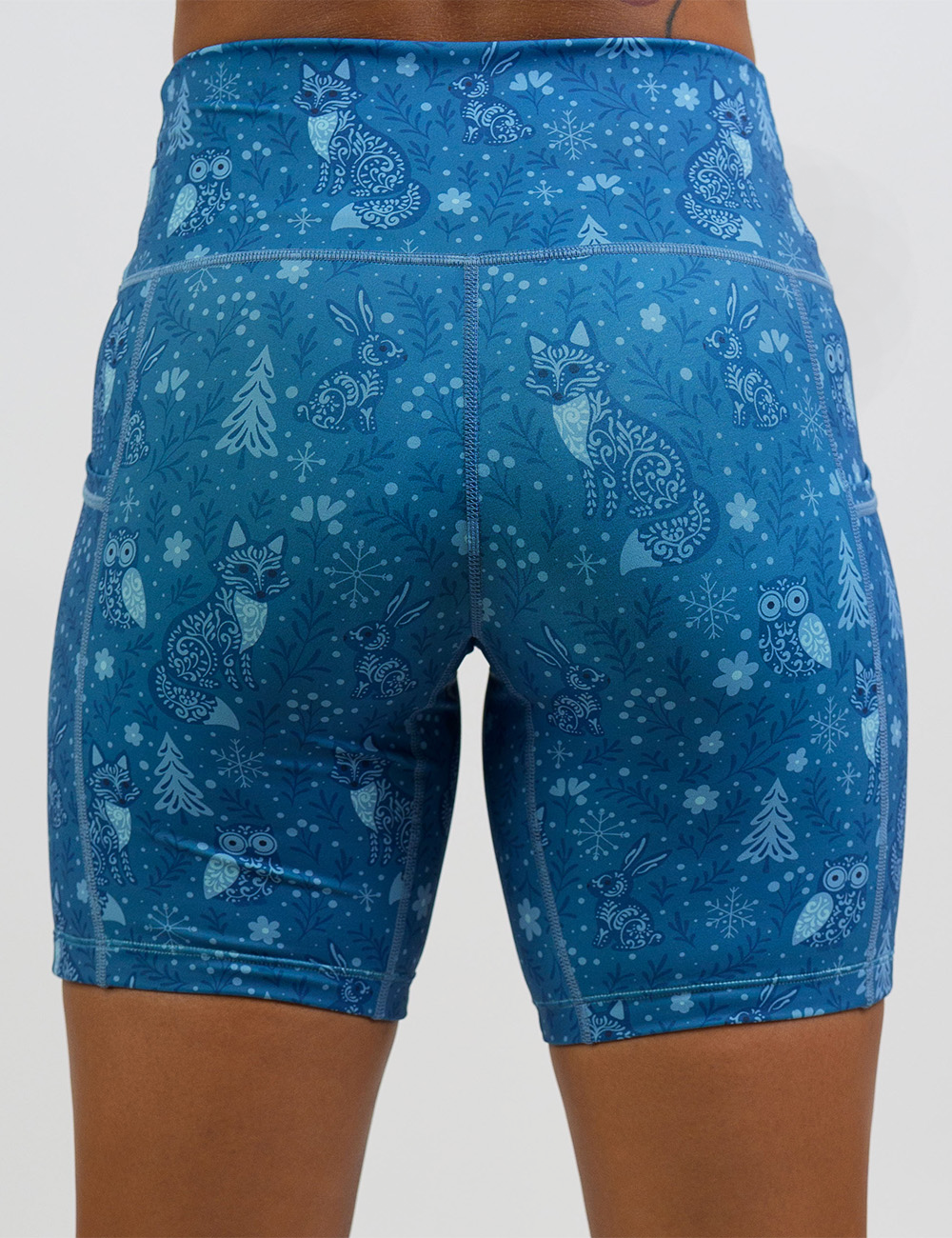 back of the 7 inch blue foxes, owls, and bunnies in a winter landscape shorts against a white background