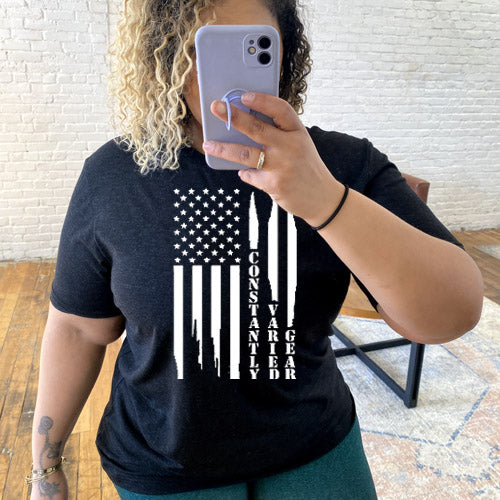 model wearing black unisex shirt with a white distressed flag design in the center