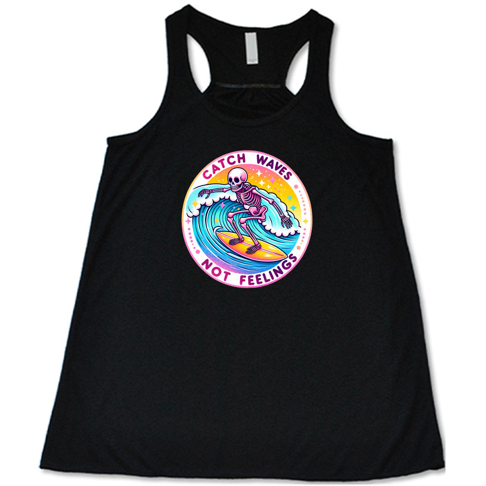 Black colored flowy tank with a skeleton surfing graphic on it that says "Catch Waves Not Feelings"