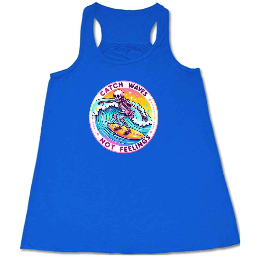 Blue colored flowy tank with a skeleton surfing graphic on it that says "Catch Waves Not Feelings"