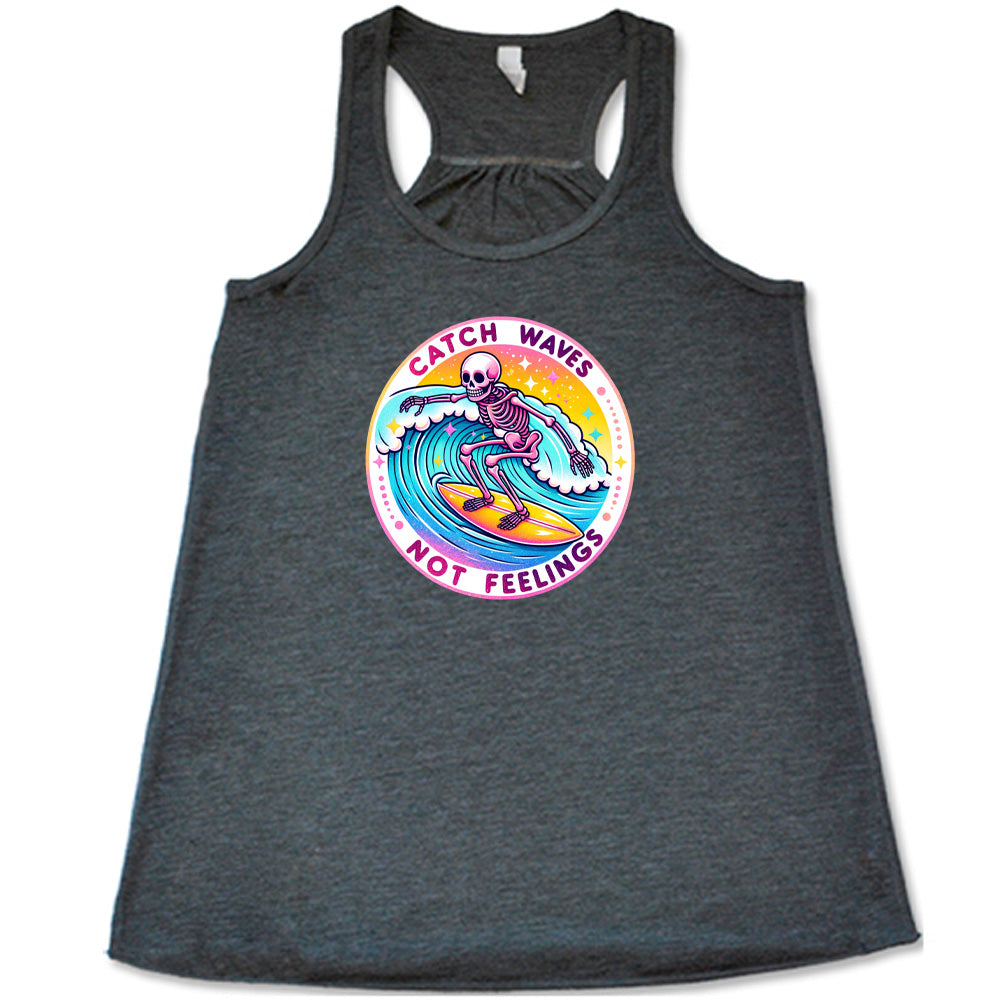 Grey colored flowy tank with a skeleton surfing graphic on it that says "Catch Waves Not Feelings"