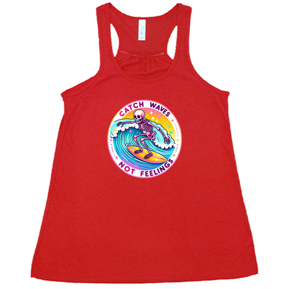 Red colored flowy tank with a skeleton surfing graphic on it that says "Catch Waves Not Feelings"