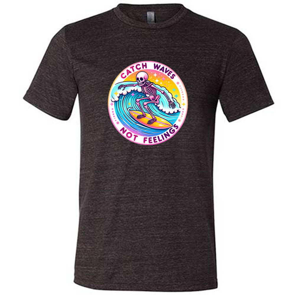 Black colored shirt with a skeleton surfing graphic on it that says "Catch Waves Not Feelings"