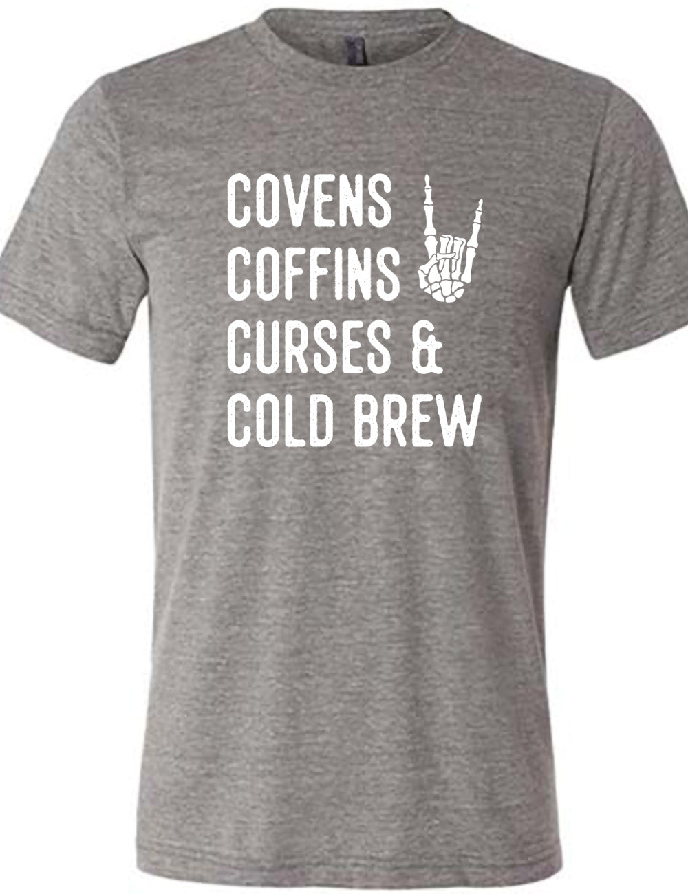 grey unisex tee with the words listed "covens coffins curses & cold brew" and the graphic of a skeletal rocker hand