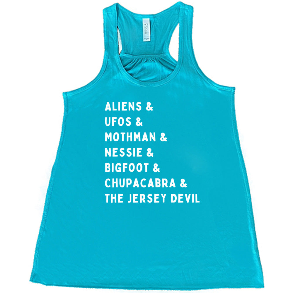 Teal colored flowy tank with graphic on it that says "ALIENS & UFOS & MOTHMAN & NESSIE & BIGFOOT & CHUPACABRA & THE JERSEY DEVIL"