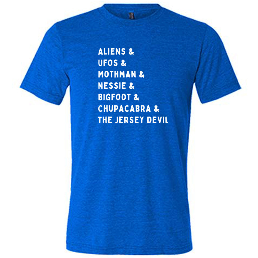 Blue colored shirt with graphic on it that says "ALIENS & UFOS & MOTHMAN & NESSIE & BIGFOOT & CHUPACABRA & THE JERSEY DEVIL"