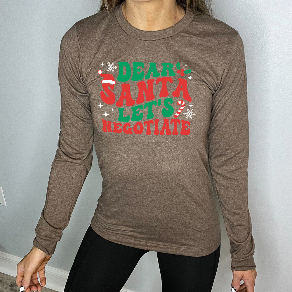 heather brown long sleeve with the words "dear santa let's negotiate" with some snowflakes, stars, and a candy cane