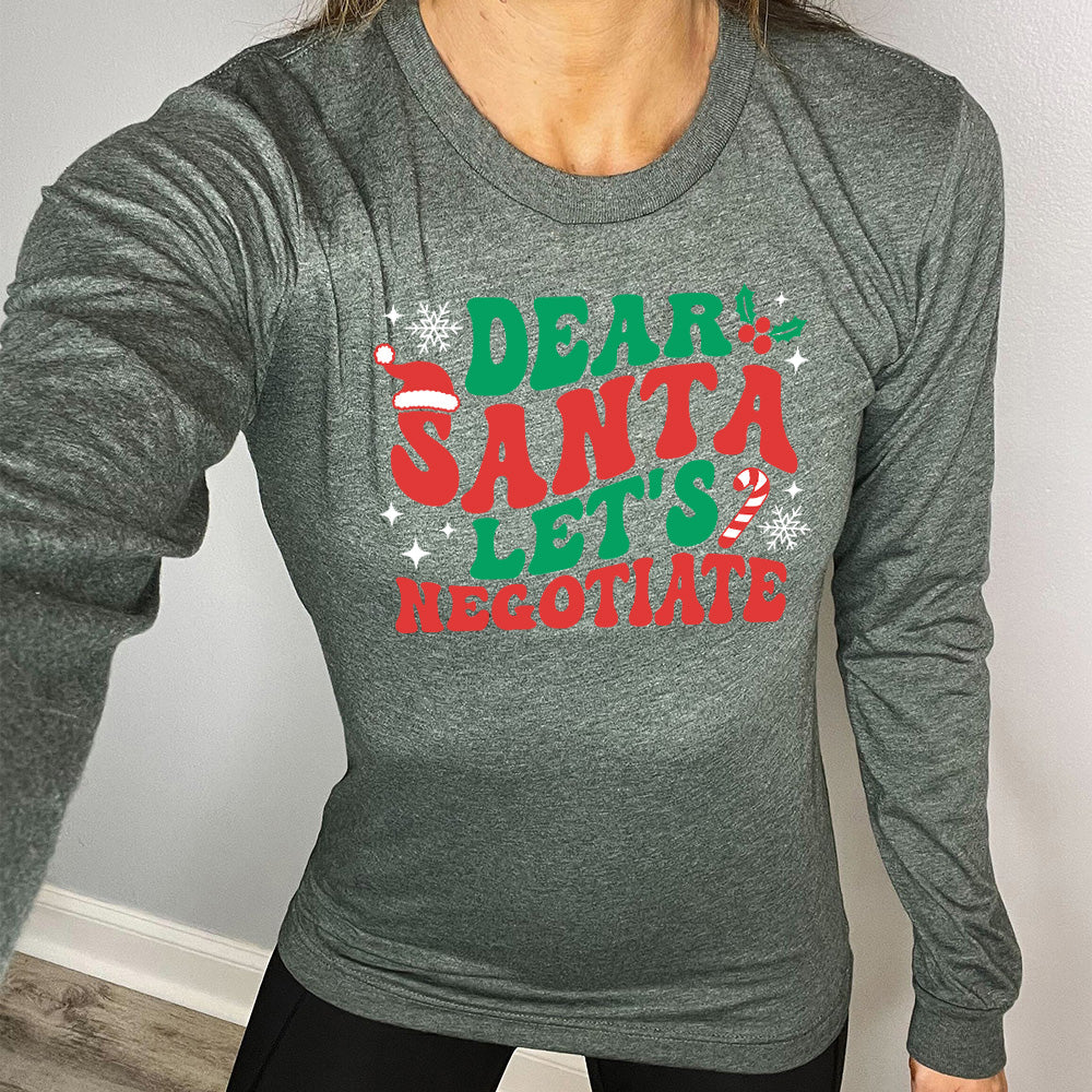 heather forest long sleeve with the words "dear santa let's negotiate" with some snowflakes, stars, and a candy cane