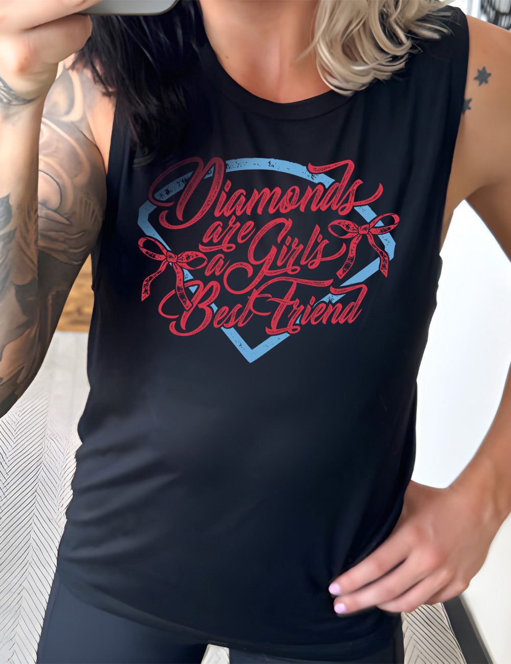 black muscle tank with the words "diamonds are a girl's best friend" on it, with two bows, all in front of a baseball diamond