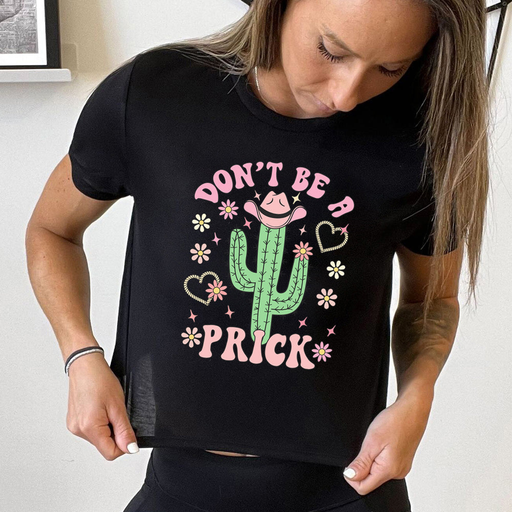 Black cropped tee with a cactus wearing a cowboy hat graphic on it that says "Don't Be A Prick"