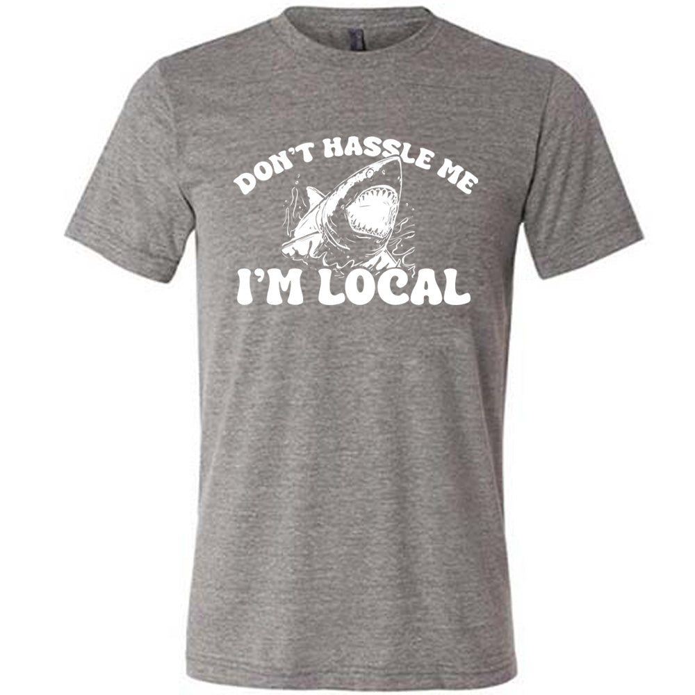 Grey colored shirt with a shark graphic on it that says "Don't Hassle Me I'm Local"