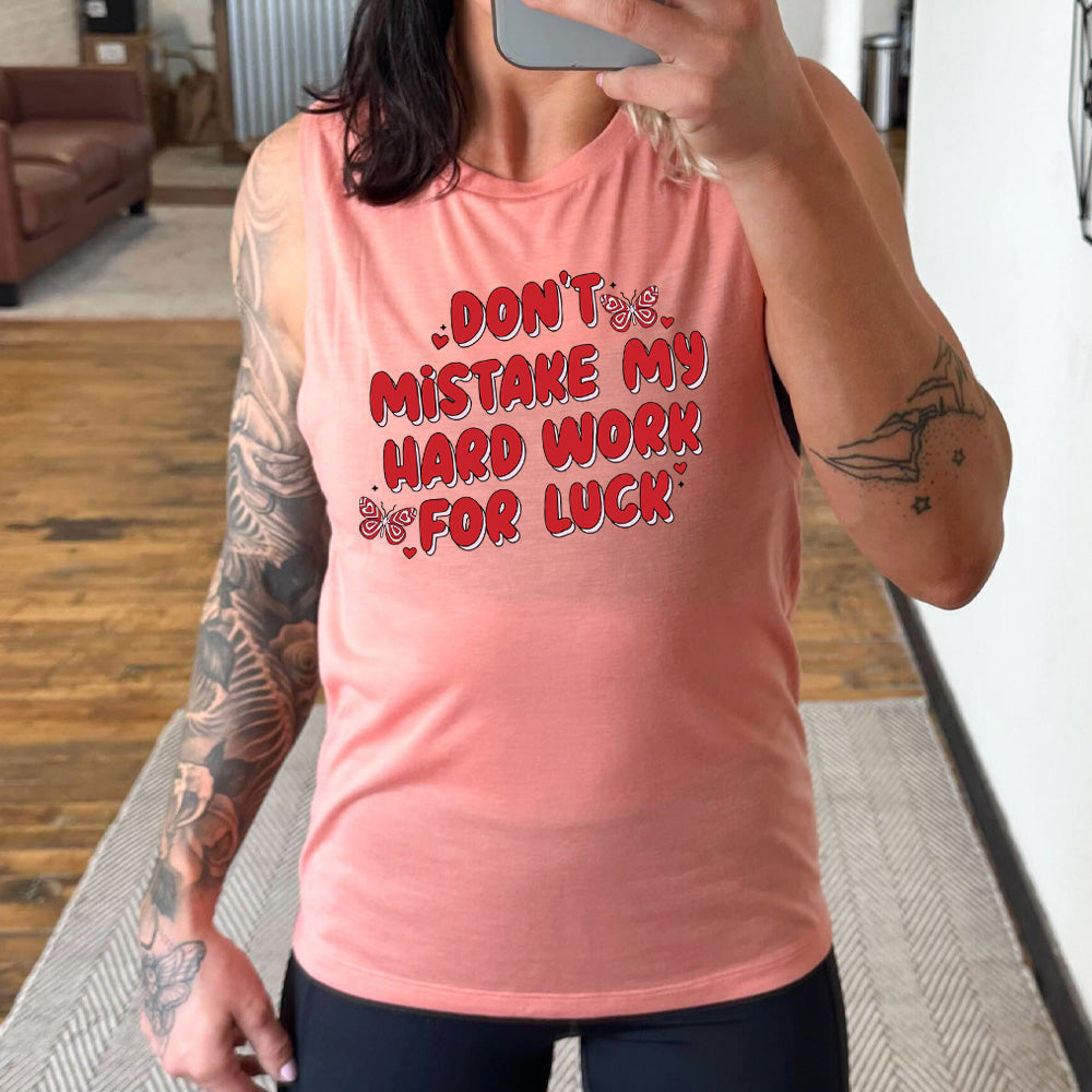 peach muscle tank with the text "Don't Mistake My Hard Work For Luck" on it, with two butterfly graphics